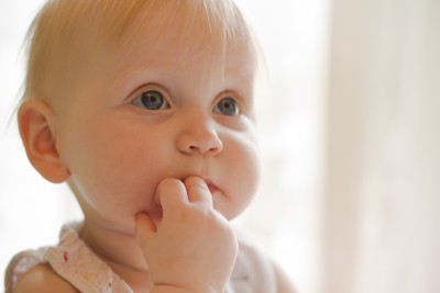 Baby with fingers in mouth eating